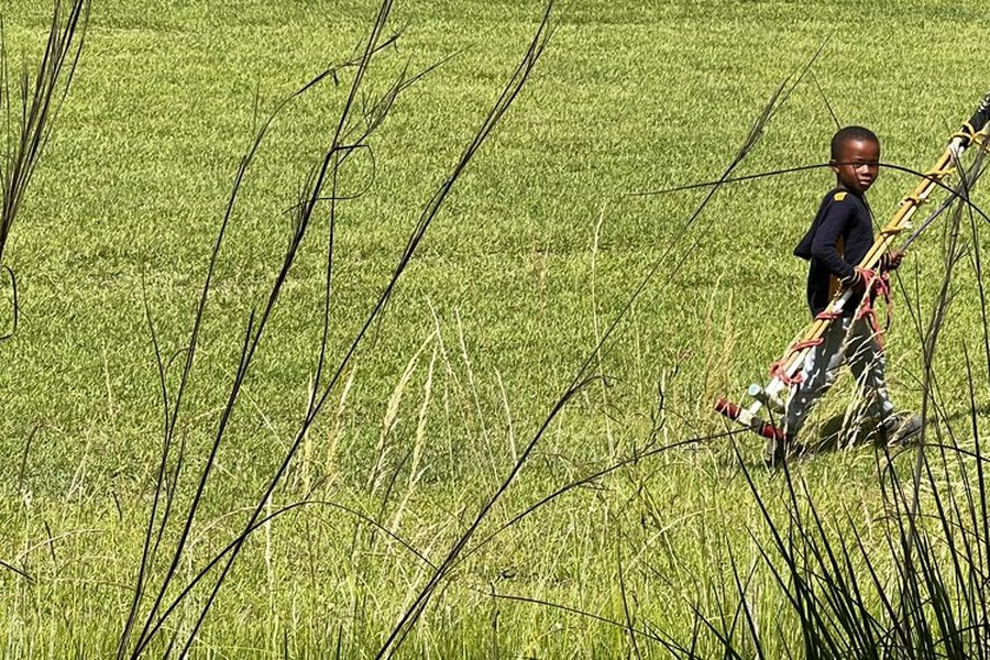 Scholar carrying polo mallets